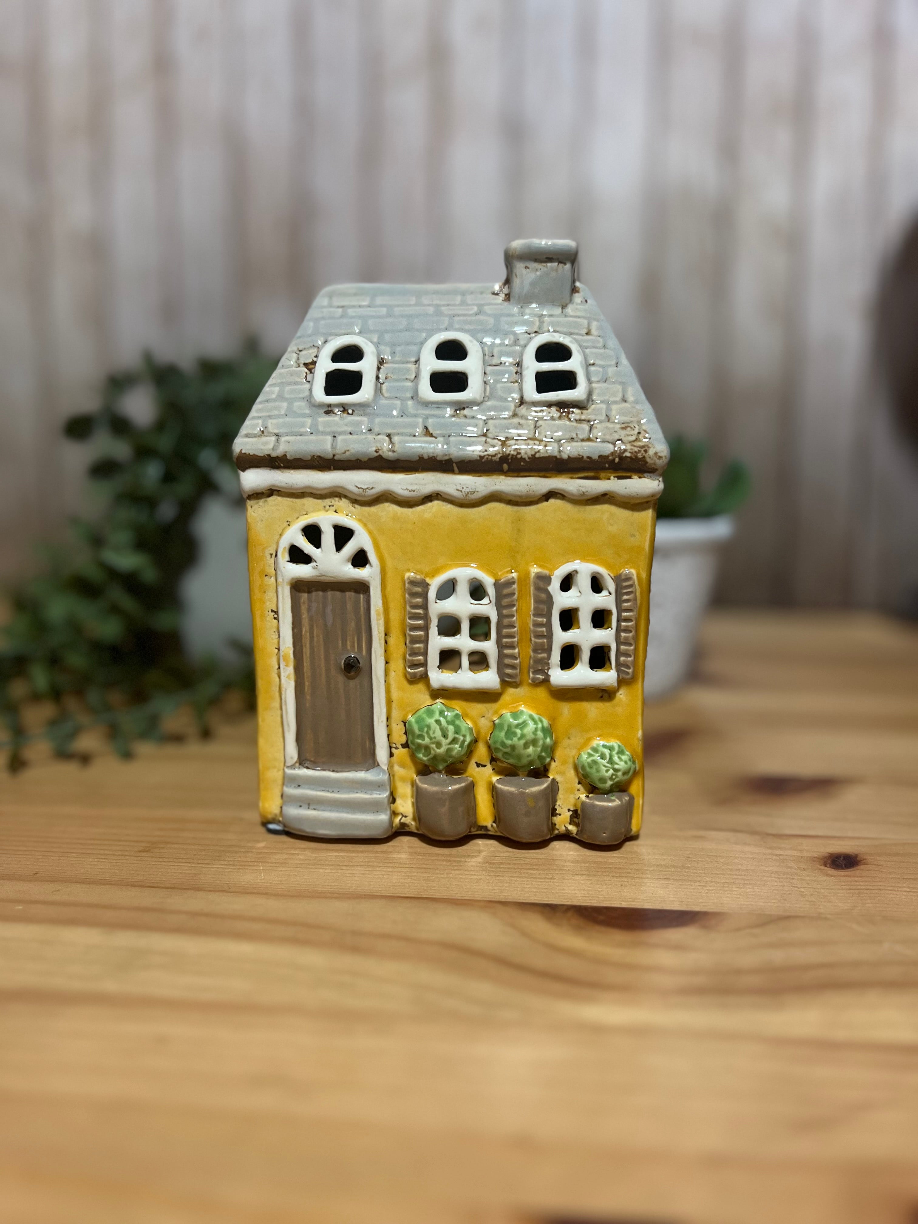 Tall Yellow House with Brown Door and Pot Plants Out Front Roof Loft Windows