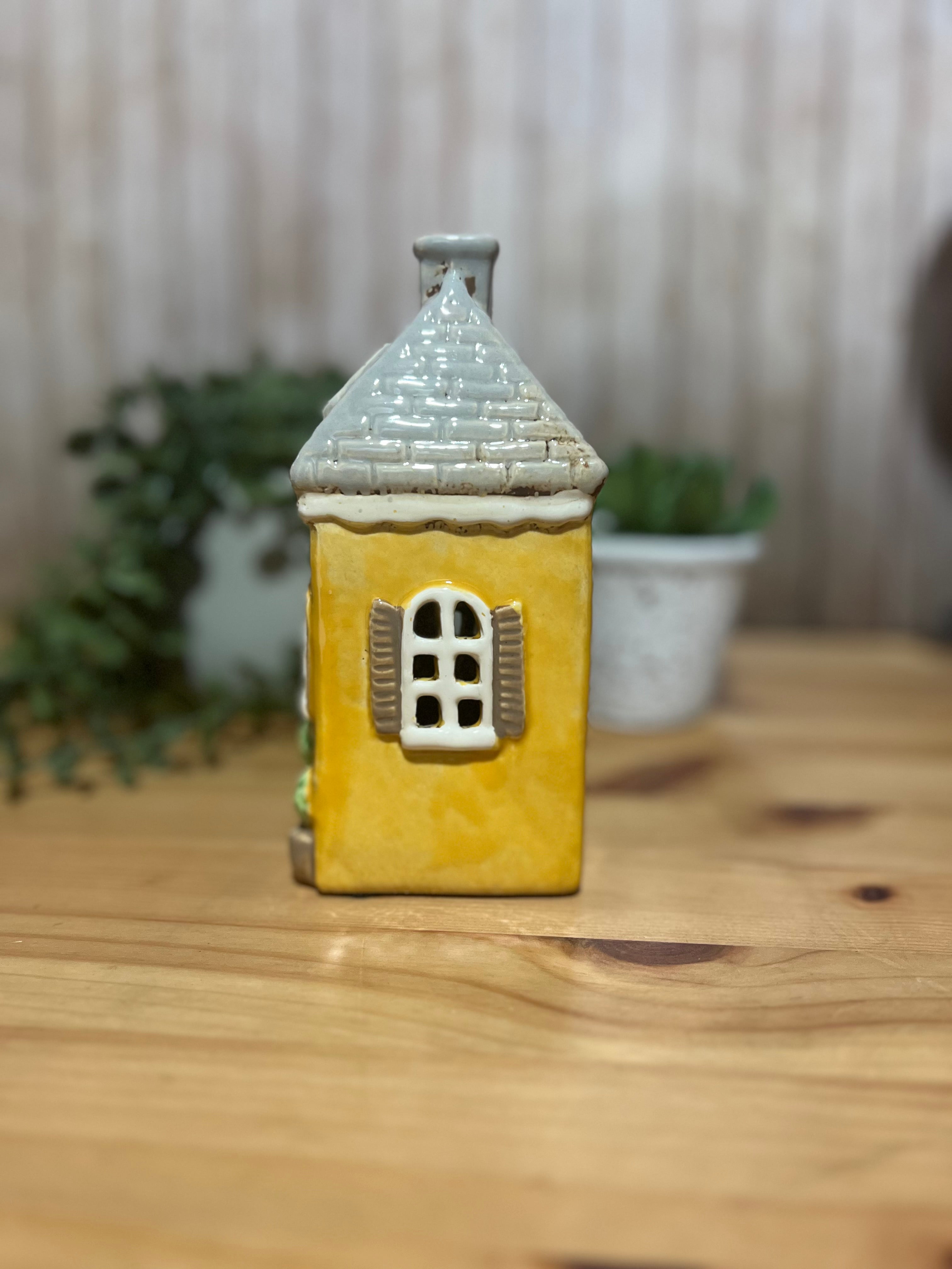 Tall Yellow House with Brown Door and Pot Plants Out Front Roof Loft Windows