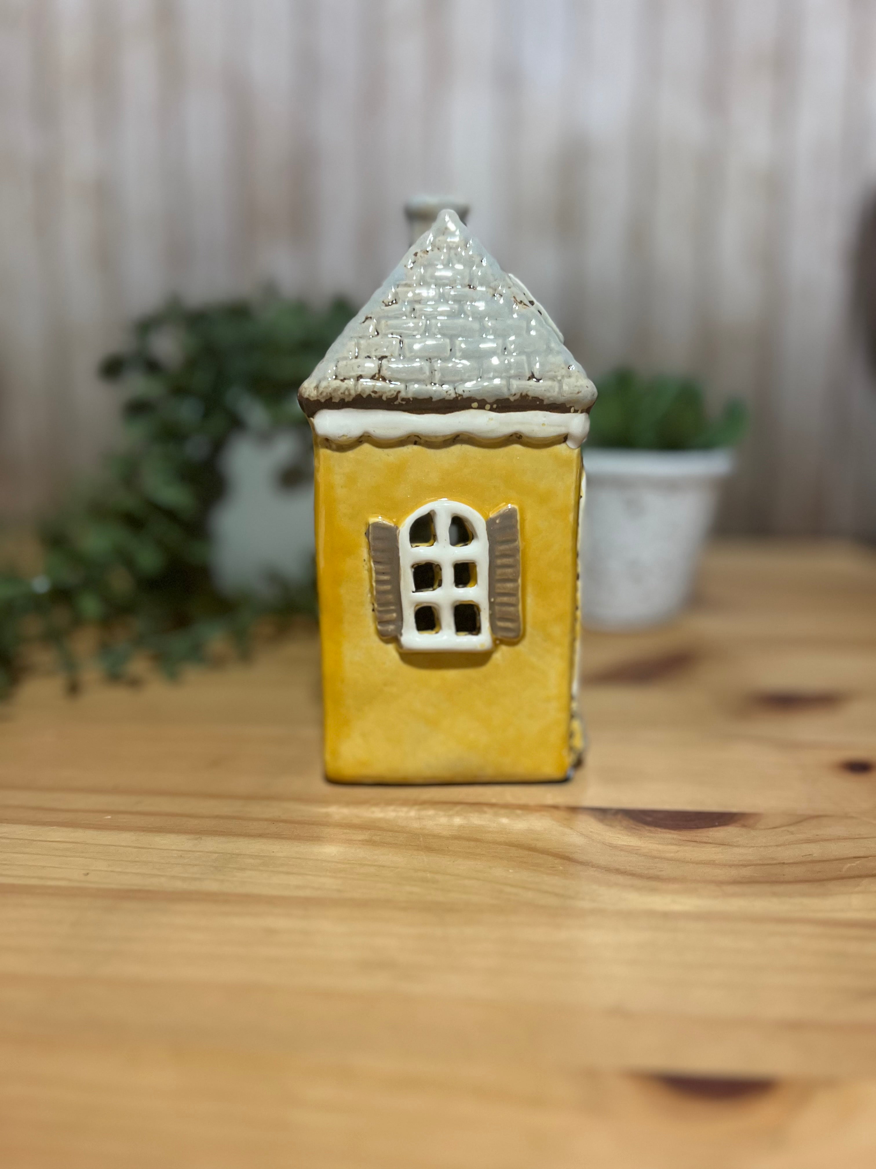 Tall Yellow House with Brown Door and Pot Plants Out Front Roof Loft Windows