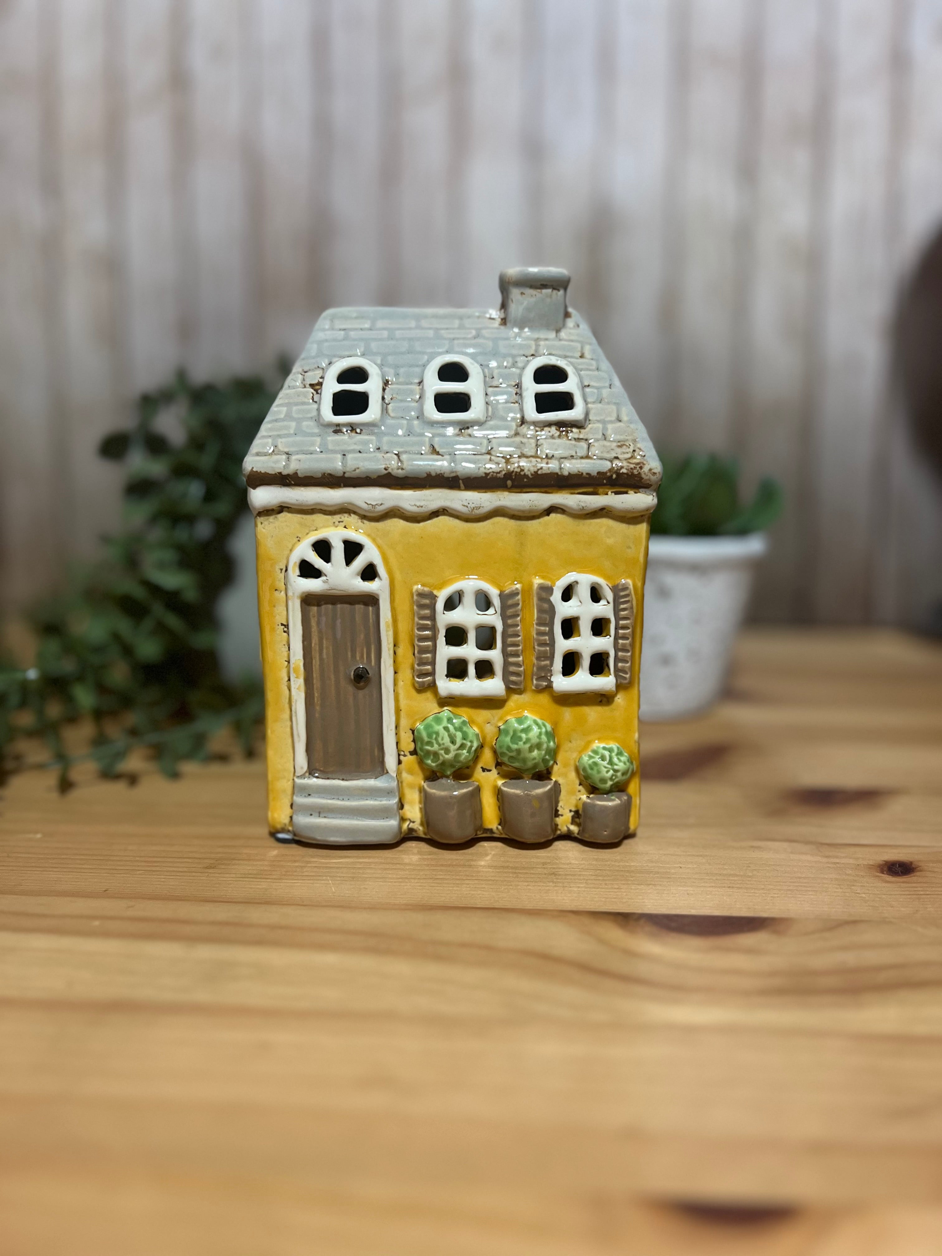 Tall Yellow House with Brown Door and Pot Plants Out Front Roof Loft Windows